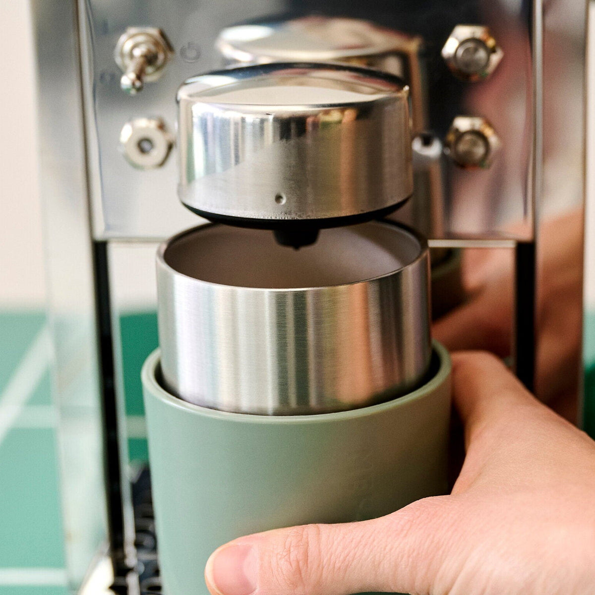 Person using a manual coffee grinder with a focus on the process.