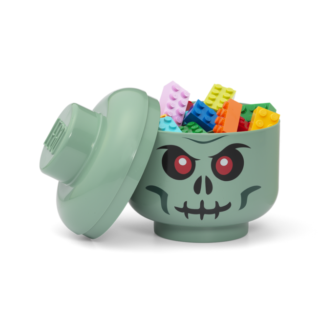 Green skull-shaped container with colorful building blocks on a white background