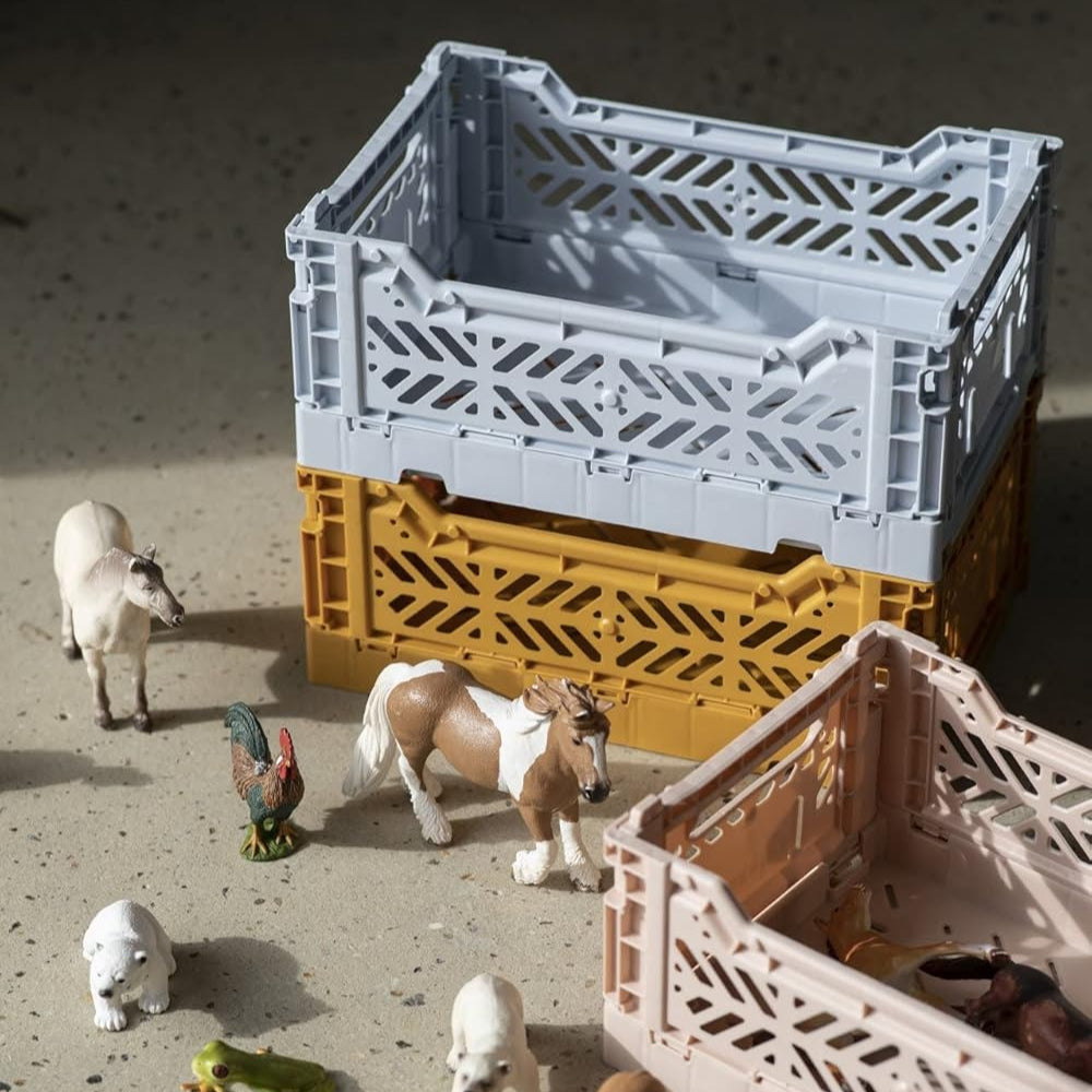 Toy animals around a small crate on a sandy surface