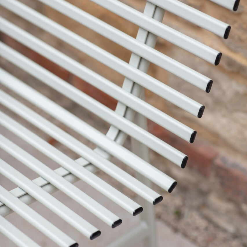 Close-up of a white metal chair with a blurred background