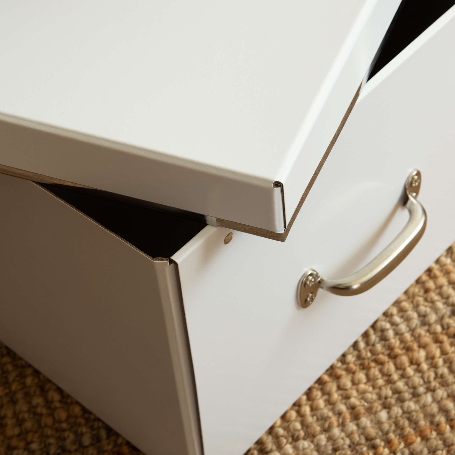 White drawer with a gold handle on a textured surface