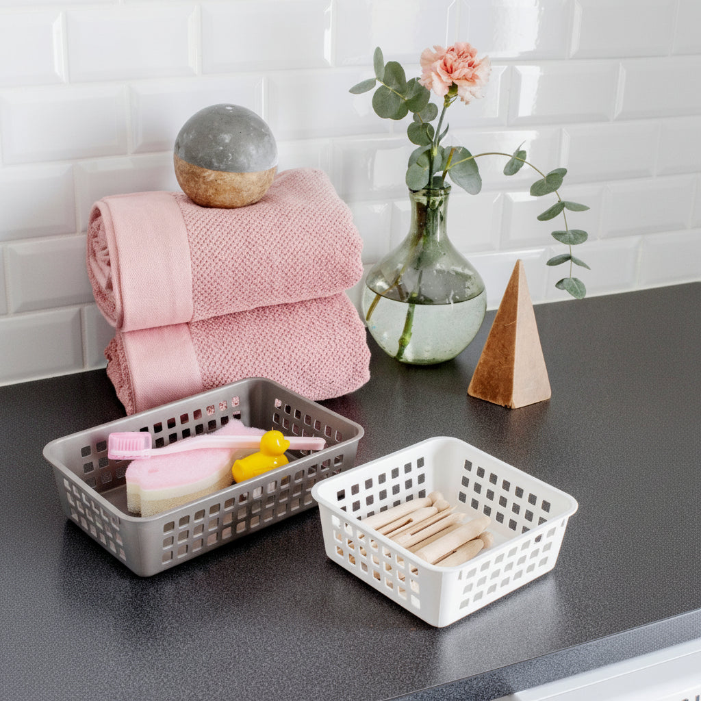 Baskets on a kitchen counter with a pink towel and decorative items.