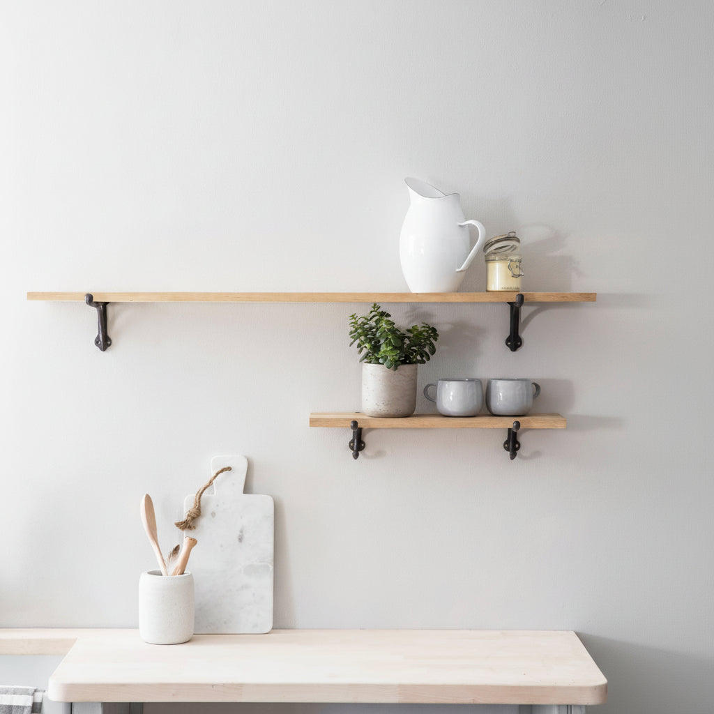 Minimalist kitchen setup with wooden shelves and a table against a white wall.