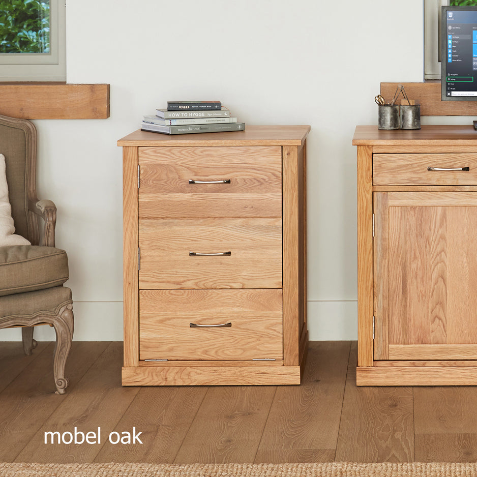 Wooden furniture pieces including a cabinet and a chair in a room setting with 'mobel oak' branding.