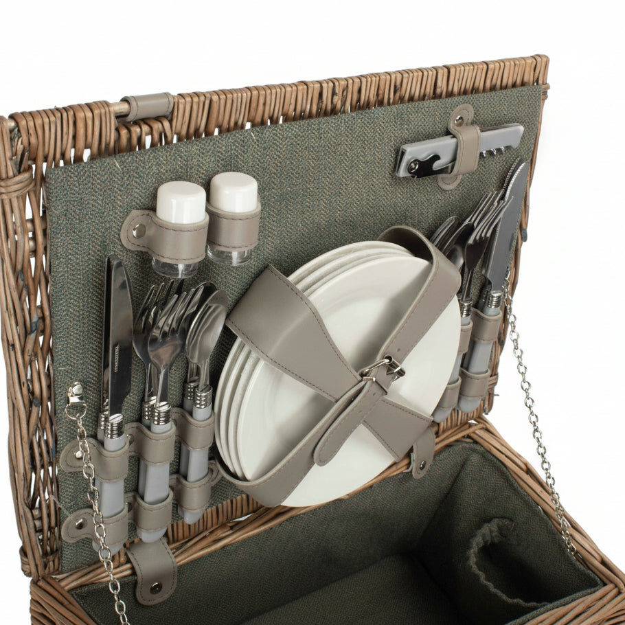 Picnic basket with cutlery, plates, and bottles on a white background