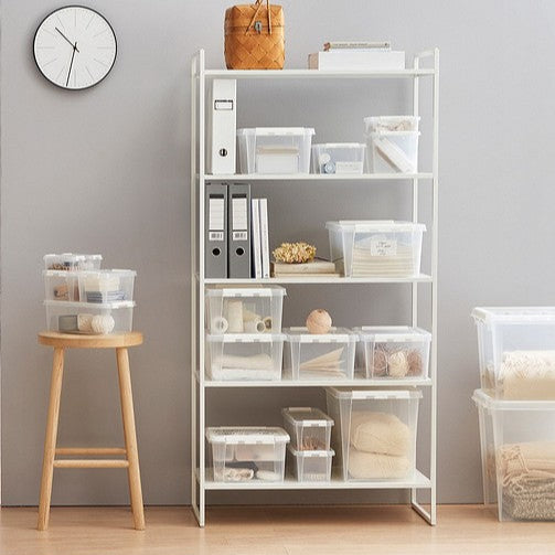 White shelving unit with storage bins against a gray wall.