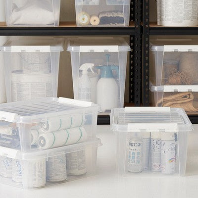 Clear storage bins with lids on a shelf with various items.