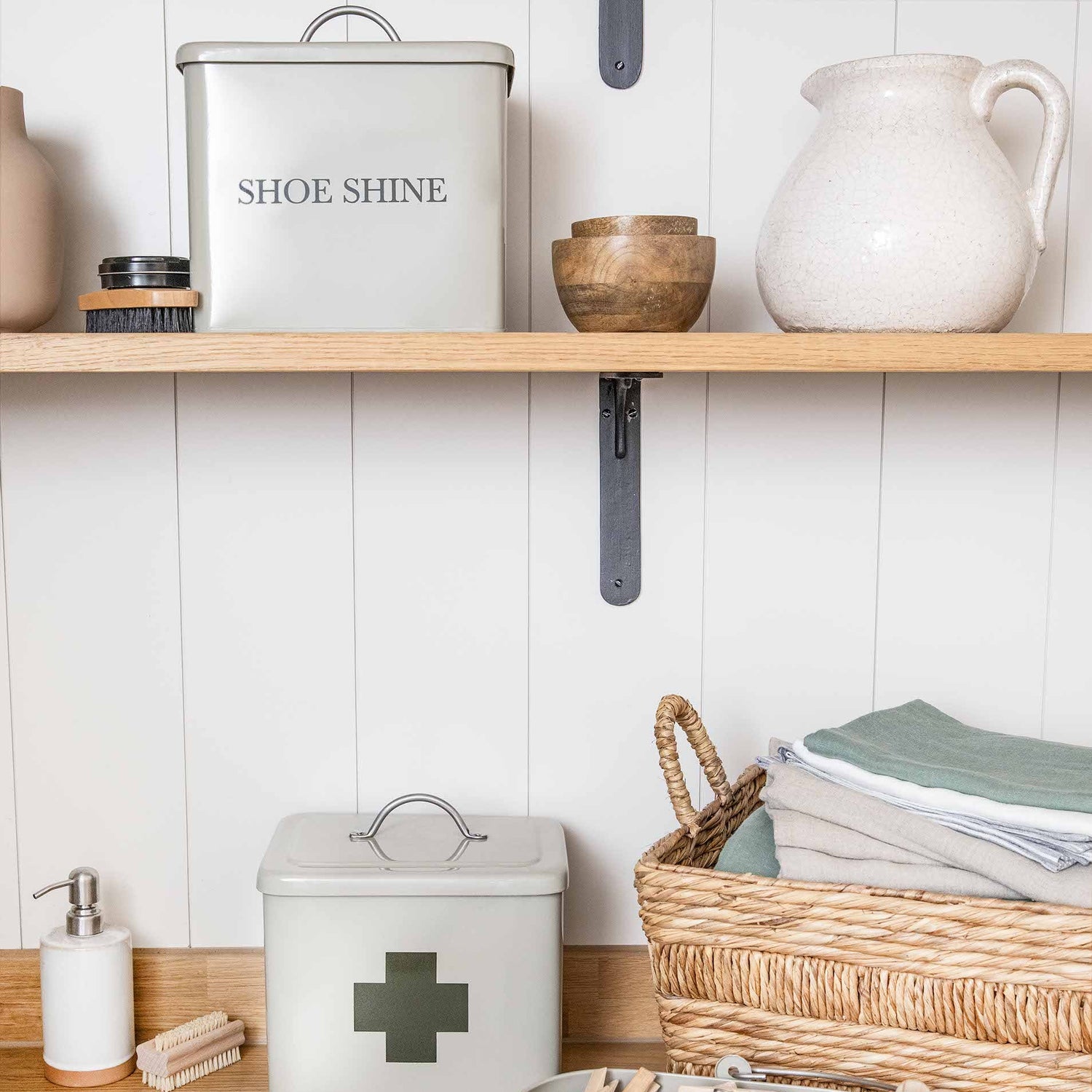 Shelves with various storage containers including a shoe shine box, medicine cabinet, and peg container.