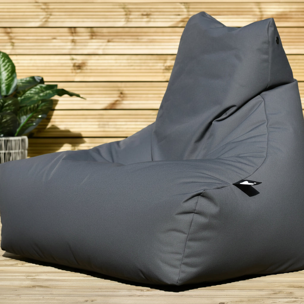 Gray bean bag chair on a wooden deck with plants in the background