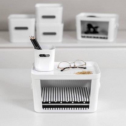 White desk organizer with stationery items on a light surface