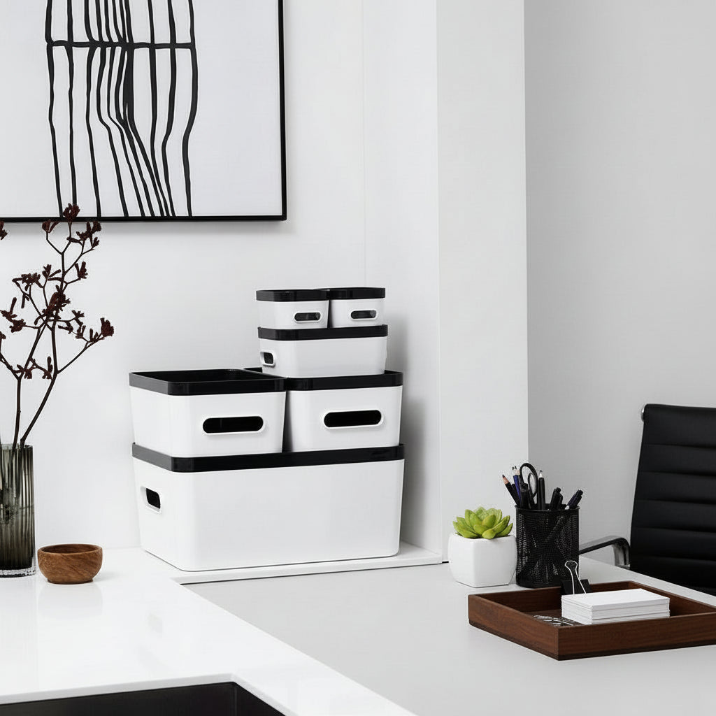 White storage boxes with black lids on a white surface, with a minimalistic background.