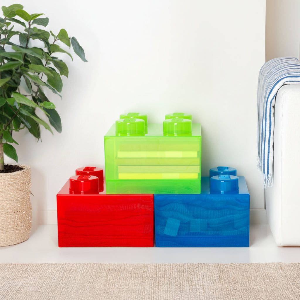 Colorful storage blocks on a shelf with a plant and sofa in the background