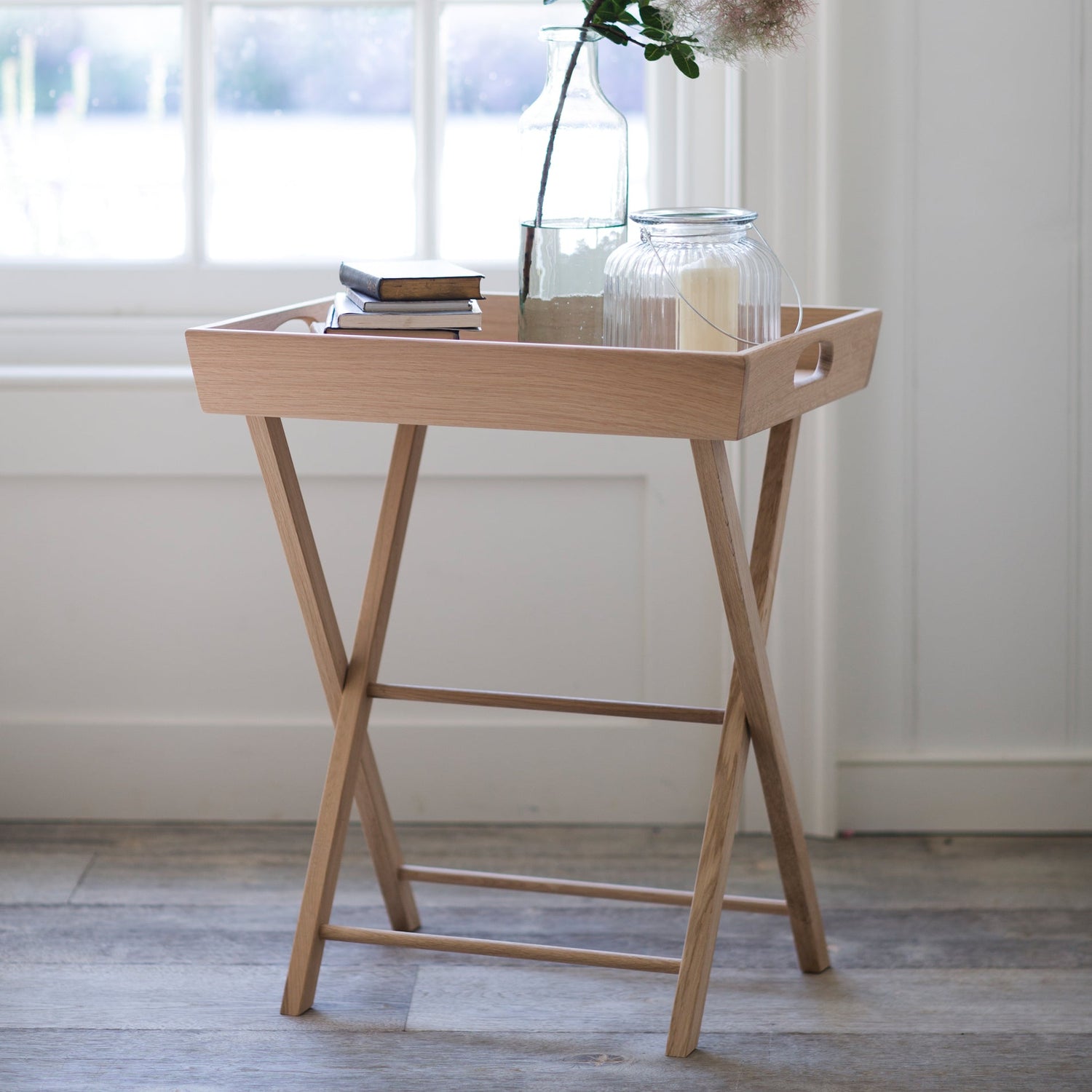 Wooden tray table with a vase of flowers in a bright room