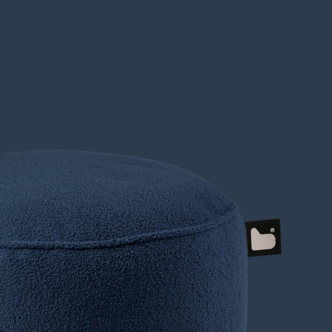 Blue ottoman with a small logo on a dark blue background