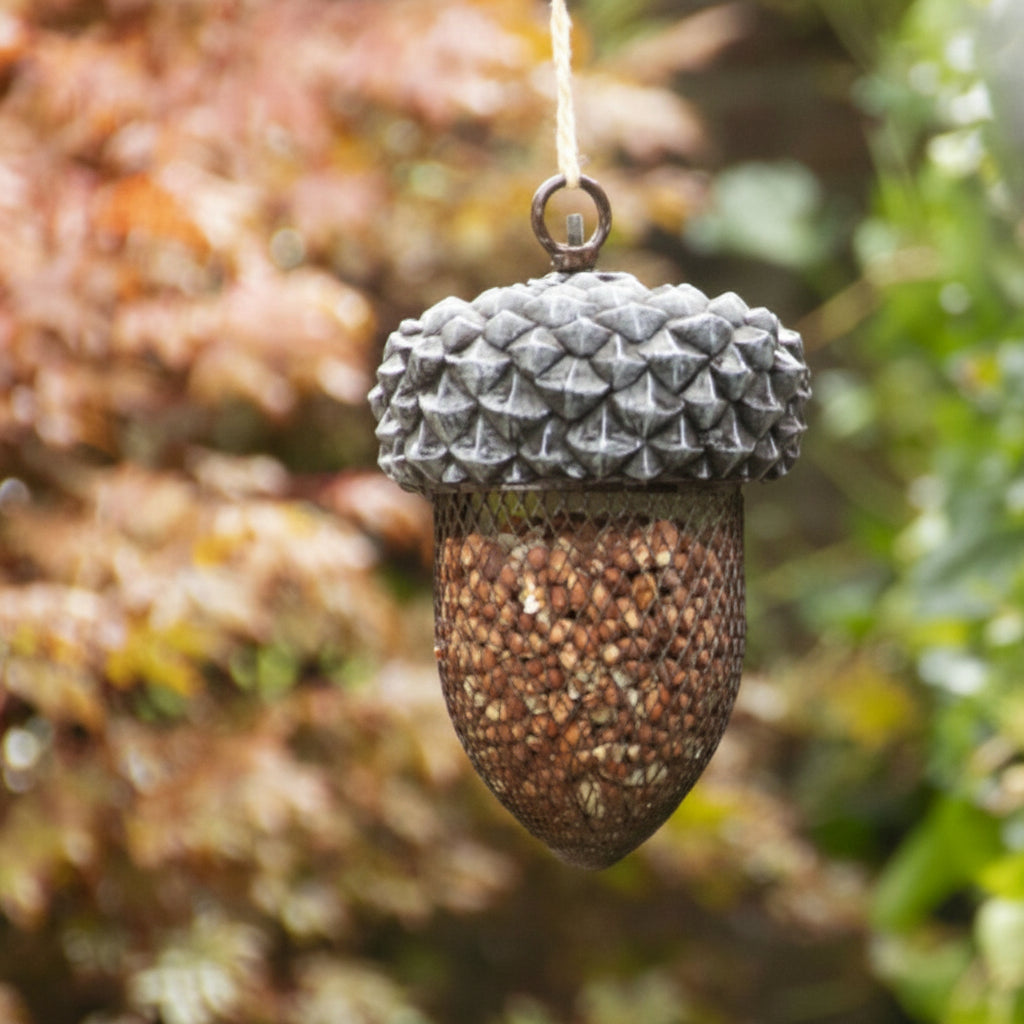 Decorative acorn ornament with textured surface against a blurred natural background