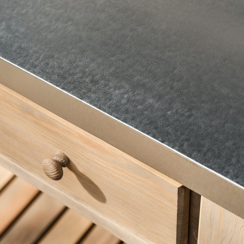 Close-up of a wooden drawer with a metallic handle on a dark stone countertop.