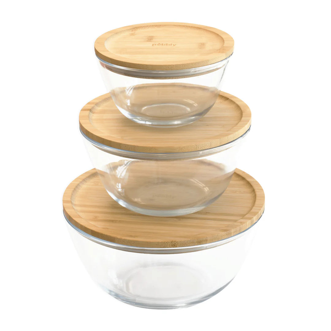 Set of glass bowls with bamboo lids on a white background