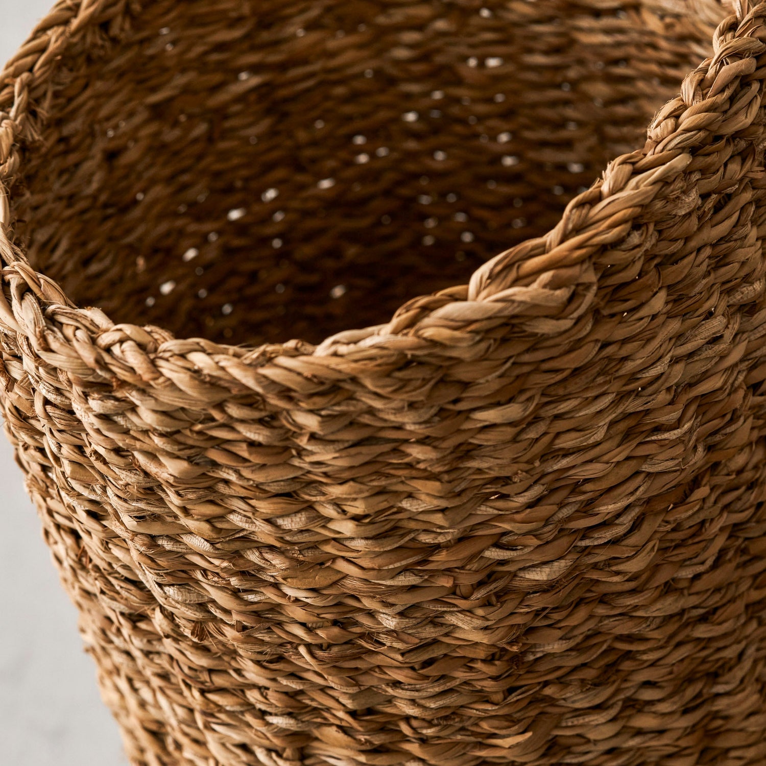Close-up of a woven brown basket on a light gray background
