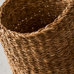 Close-up of a woven brown basket on a light gray background