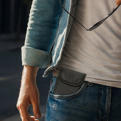 Person wearing a blue denim jacket and jeans with a blurred background