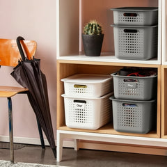 Storage baskets on a wooden shelf with a cactus plant and an umbrella in the background.