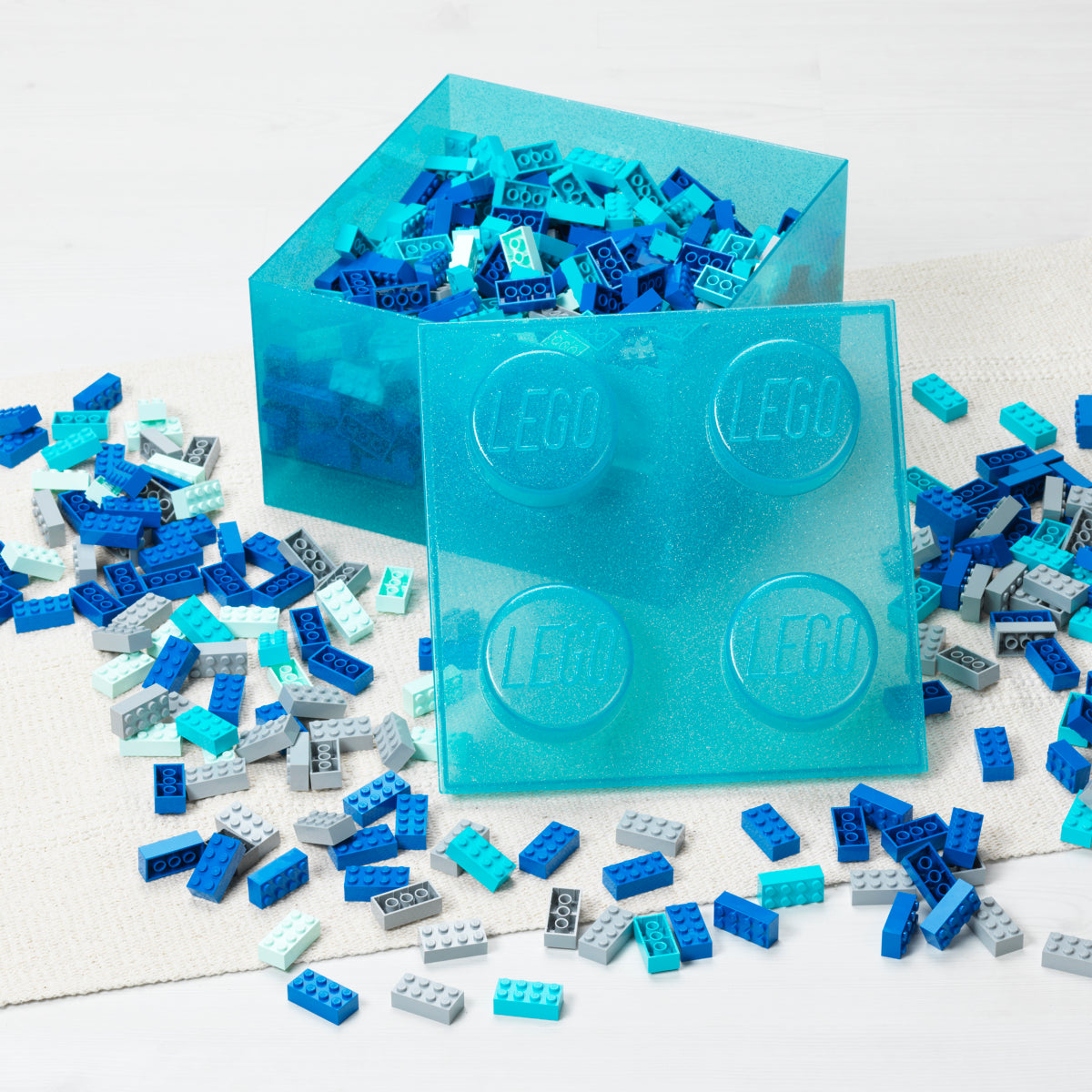 Blue LEGO bricks and clear LEGO mold on a white background