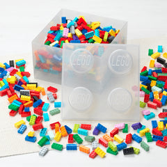 Colorful LEGO bricks with clear storage containers on a white background