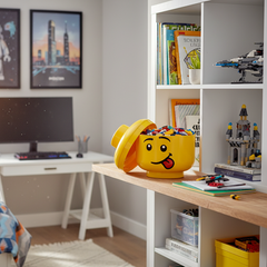 Yellow storage container shaped like a lego figure head with colorful blocks inside on a white background