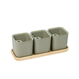 Set of three green square pots on a wooden tray with a white background