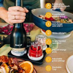 Black spice grinder with features highlighted on a table with food in the background