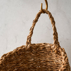 Woven basket with a handle on a neutral background