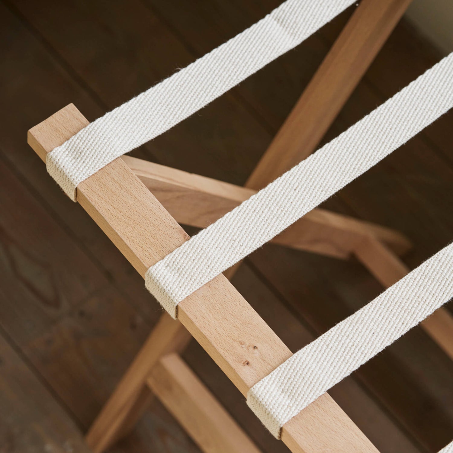 Wooden chair with white straps on a wooden floor