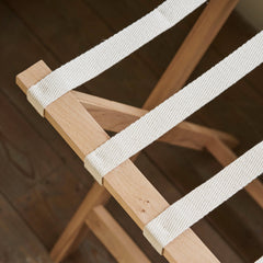 Wooden chair with white straps on a wooden floor