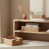 Set of three woven baskets with lids on a white background