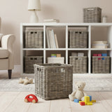 Children's room with white bookshelf, wicker baskets, and toys on a wooden floor.