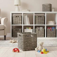 Children's room with white bookshelf, wicker baskets, and toys on a wooden floor.