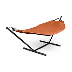 An orange quilted hammock suspended on a black metal stand, shown against a plain white background.