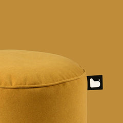 Mustard yellow ottoman with a brand logo on a matching background