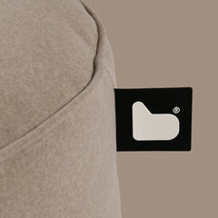 Close-up of a beige fabric with a black label featuring a white logo on a beige background