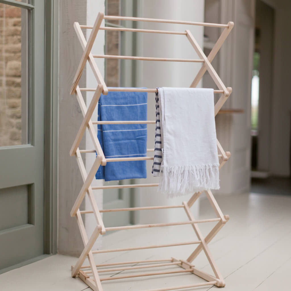 Wooden towel rack with blue and white towels in a bathroom setting