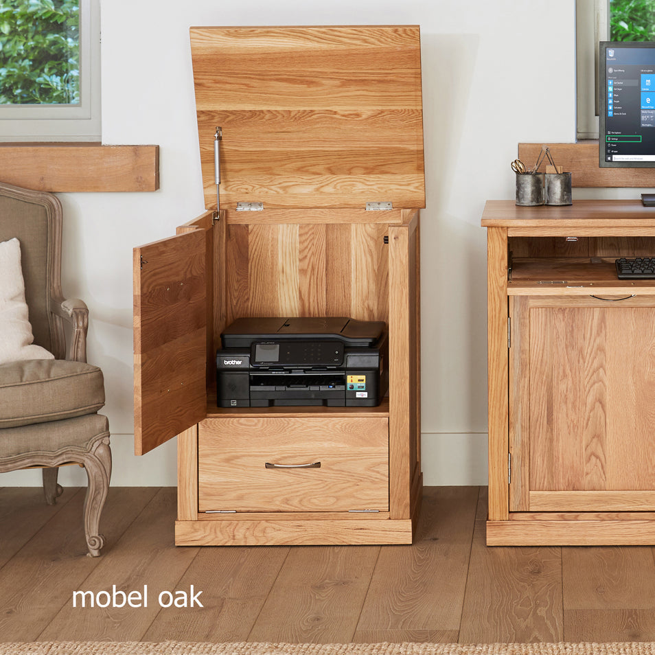 Wooden cabinet with open door revealing printer, surrounded by home office furniture.