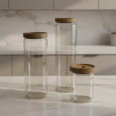 Set of three glass jars with wooden lids on a white background