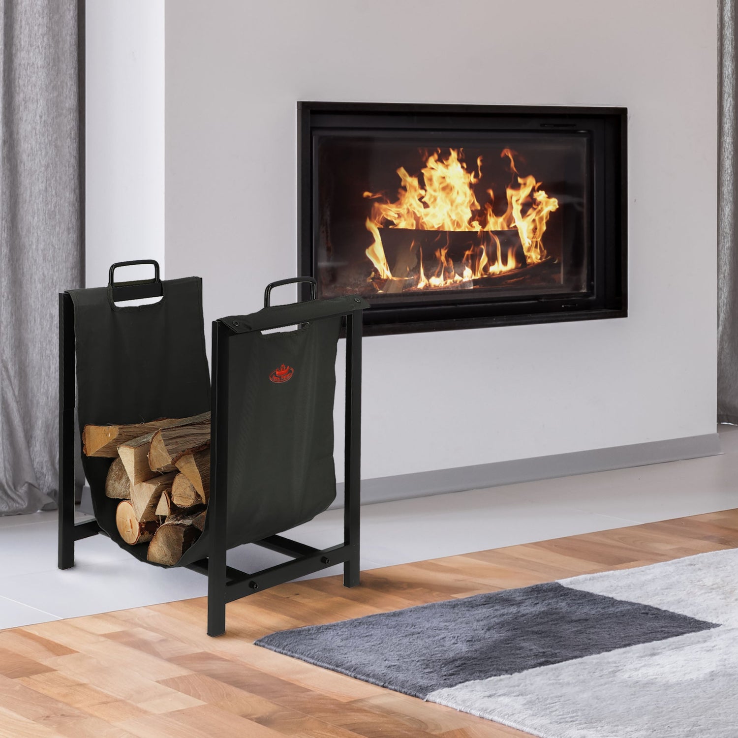 Modern fireplace with burning logs and a black metal firewood holder in a room with light gray walls and wooden floor.