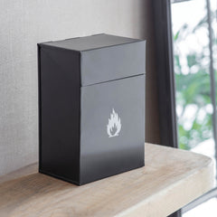 Black rectangular box with a white flame logo on a wooden surface.