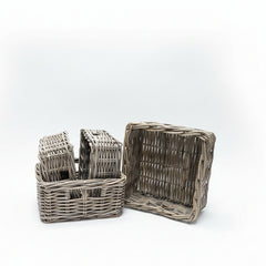 Three wicker baskets on a cardboard surface with a brick wall background