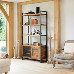 Living room with a bookshelf, armchair, and sofa near a window.