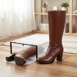 high-heeled boots on a clear platform stand against a white background