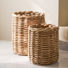 Two woven baskets on a light surface with a neutral background