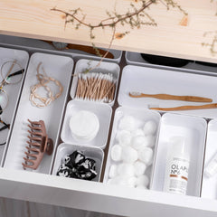 Organized drawer with various items including glasses, hair accessories, and skincare products.