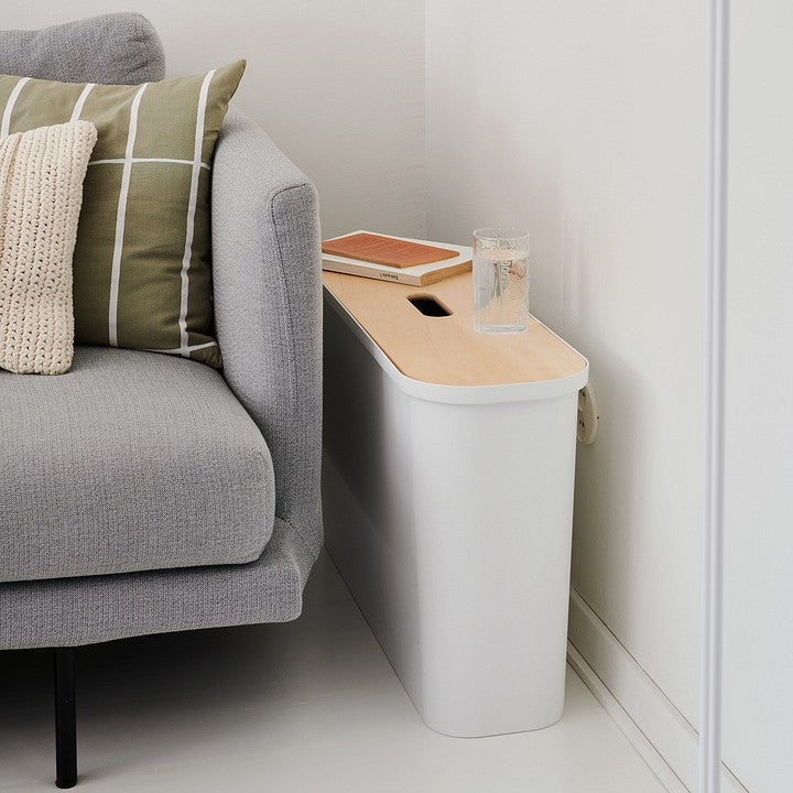 Gray sofa with a small wooden table next to it in a minimalistic living room.